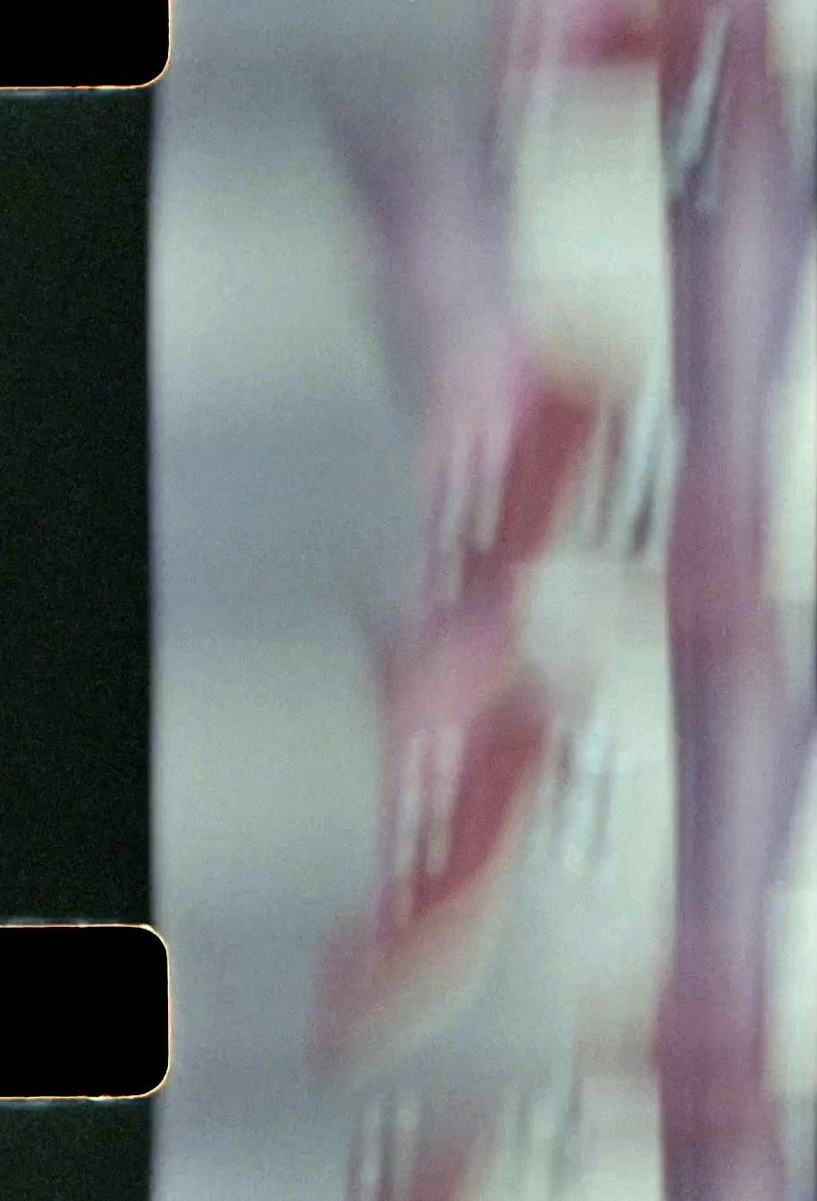 Distorted 8mm film still of dancers' footwork in red flamenco shoes.